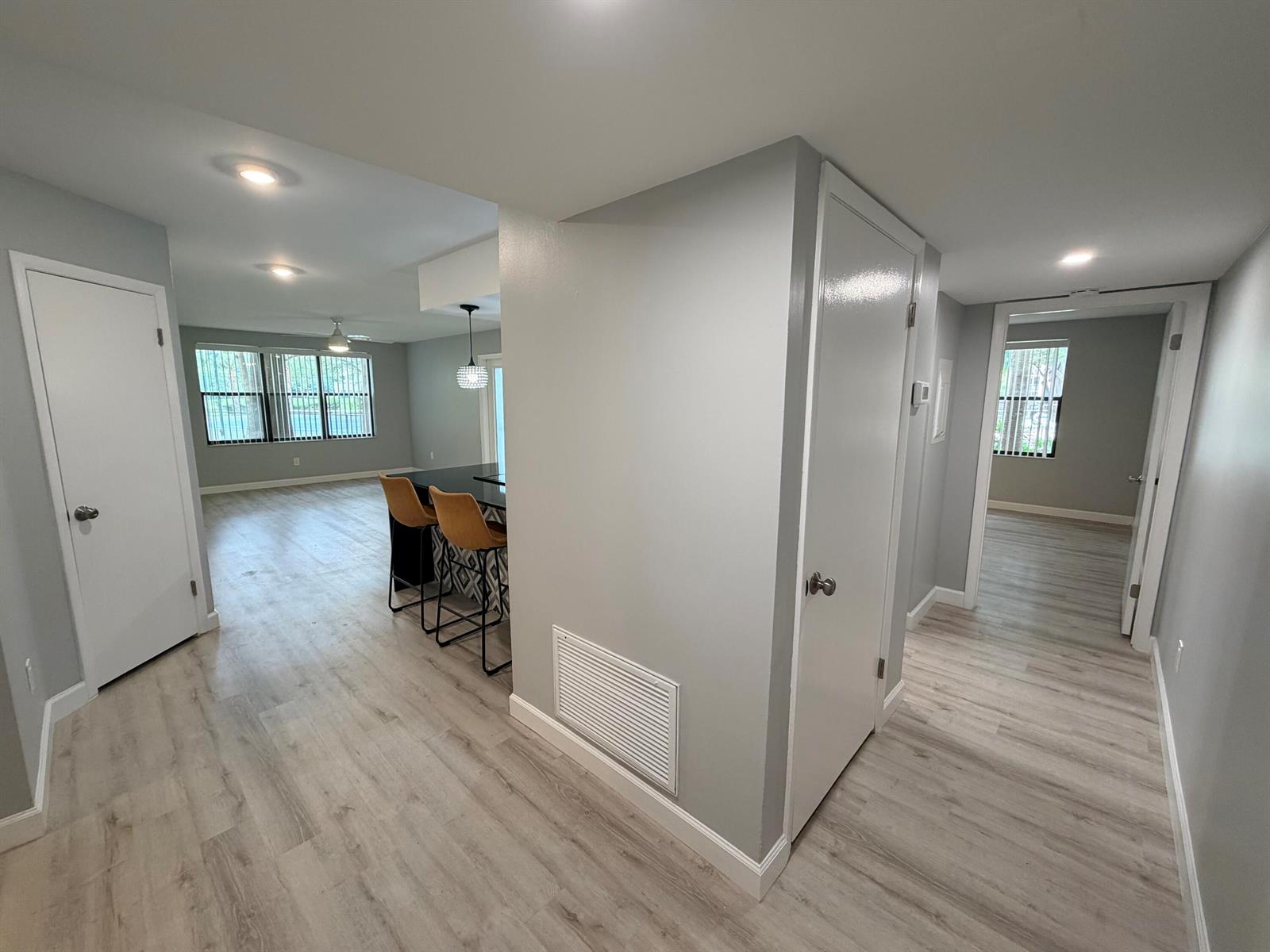 An interior view shows a hallway with light wood flooring, gray walls, and white doors — 4501 W Mcnab Road # 11, Pompano Beach FL 33069, POMPANO BEACH, FL