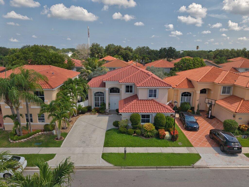 A two-story house with a red tile roof, beige stucco exterior, and a paved driveway — 6579 Constance Street, Lake Worth FL 33467, LAKE WORTH, FL