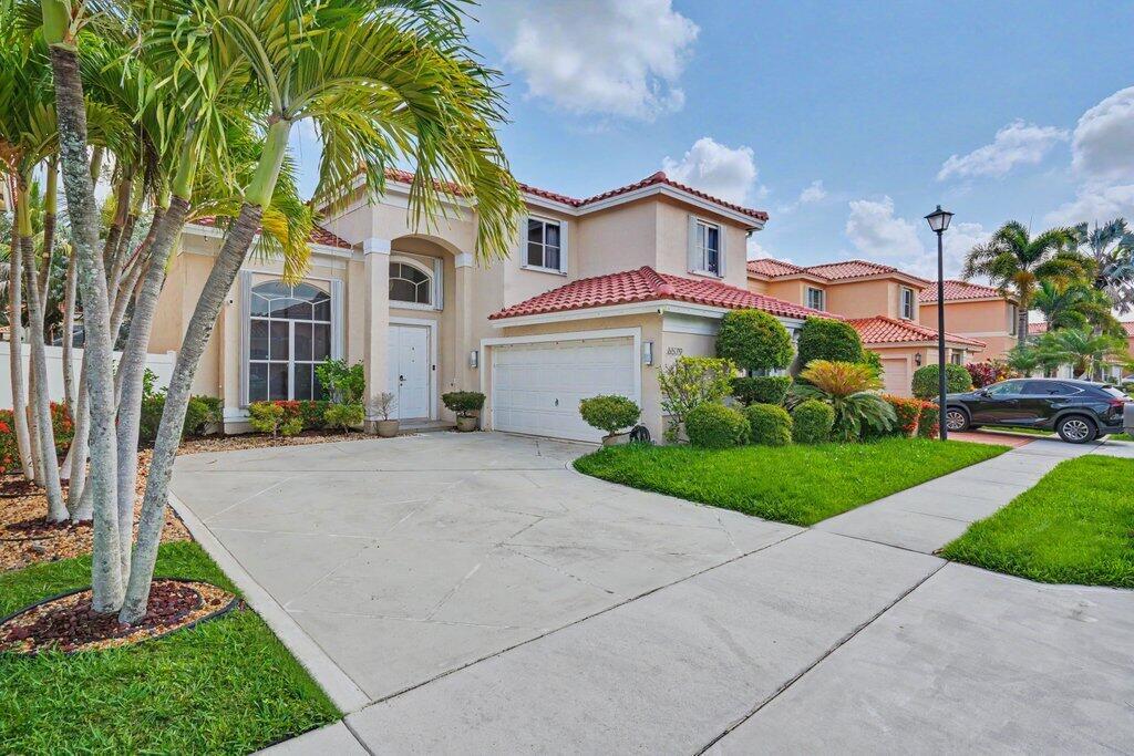 An aerial view of a two-story suburban house with a red tile roof and driveway — 6579 Constance Street, Lake Worth FL 33467, LAKE WORTH, FL