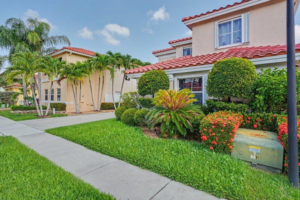 A two-story suburban house with a tile roof, white garage, and palm trees in front — 6579 Constance Street, Lake Worth FL 33467, LAKE WORTH, FL