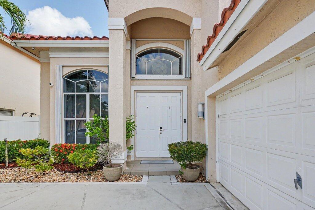 A two-story house with a red tile roof, palm trees, and a landscaped front yard — 6579 Constance Street, Lake Worth FL 33467, LAKE WORTH, FL