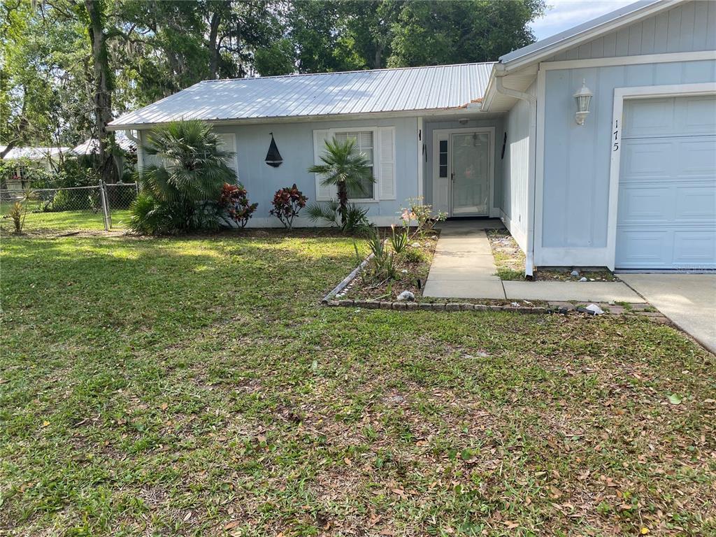A light blue house with a metal roof and a concrete walkway leading to the entrance — 175 CONRAD STREET, PORT ORANGE, FL