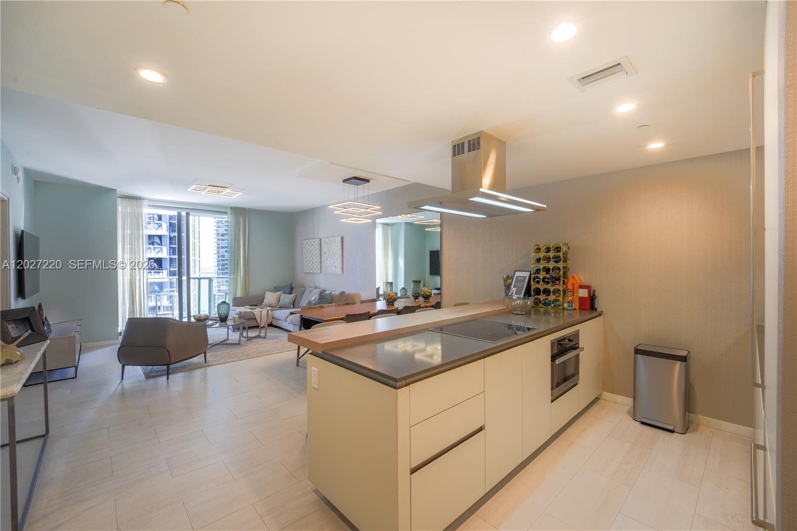 A modern kitchen island with a cooktop sits in an open-concept living area — 1000 Brickell Plz # 3705, Miami FL 33131, MIAMI, FL