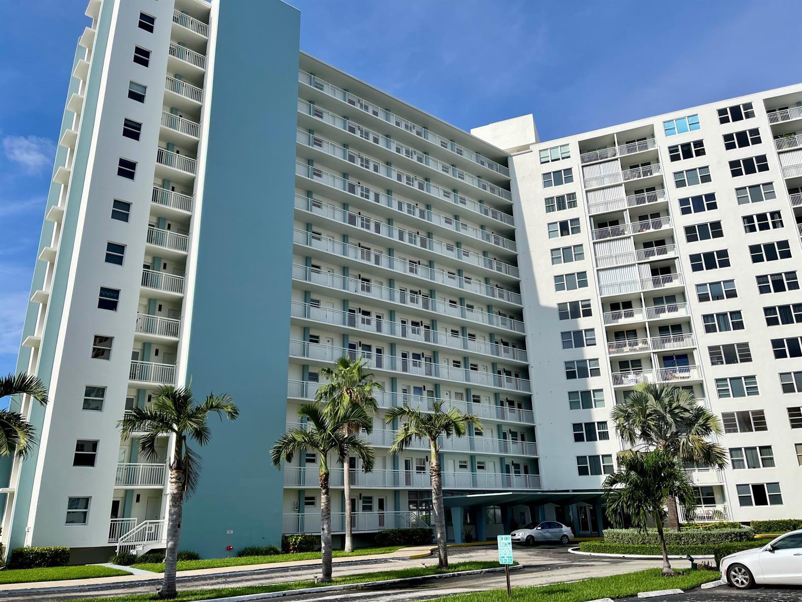 A tall, multi-story apartment building with balconies and palm trees in front — 201 N Ocean Boulevard # 302, Pompano Beach FL 33062, POMPANO BEACH, FL