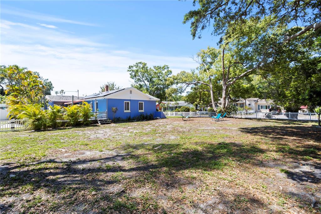 A blue house sits on a large, grassy lot with mature trees and a fence — 2800 TIFTON ST UNIT 3, GULFPORT, FL
