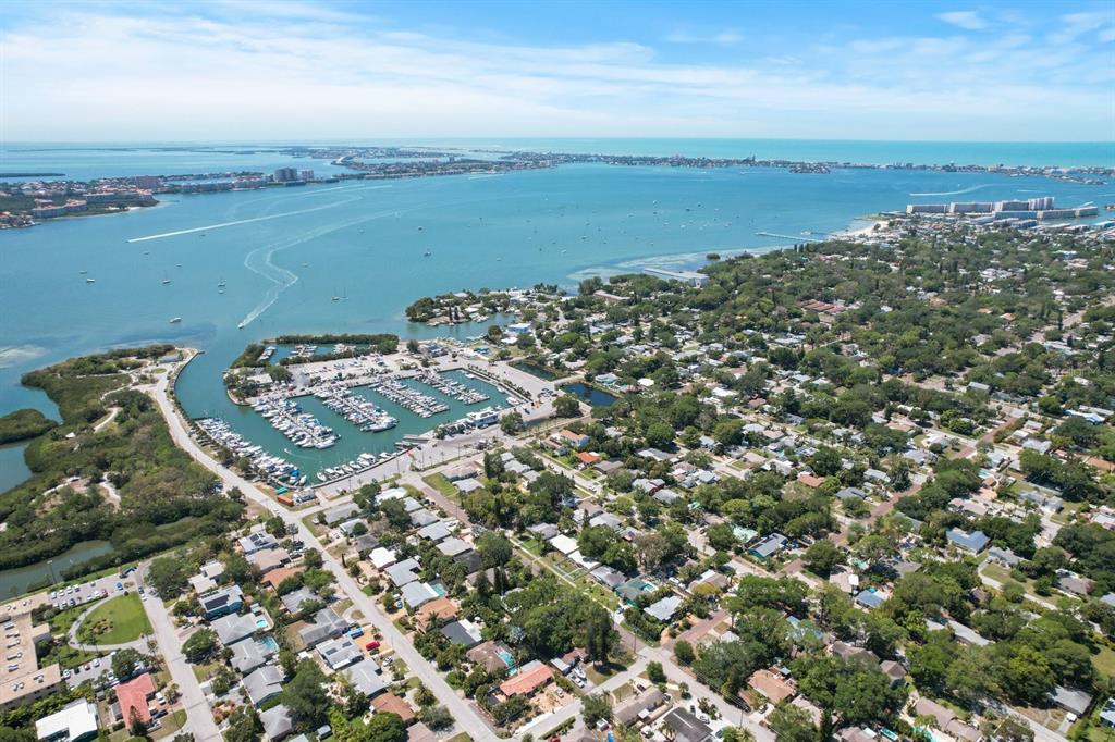 An aerial view shows a coastal neighborhood with a marina, residential homes, and water — 2800 TIFTON ST UNIT 3, GULFPORT, FL