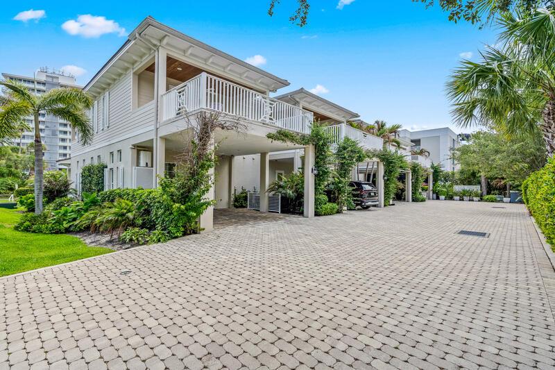 A multi-story residential building features a paved driveway, covered parking, and balconies with white railings — VERO BEACH, FL