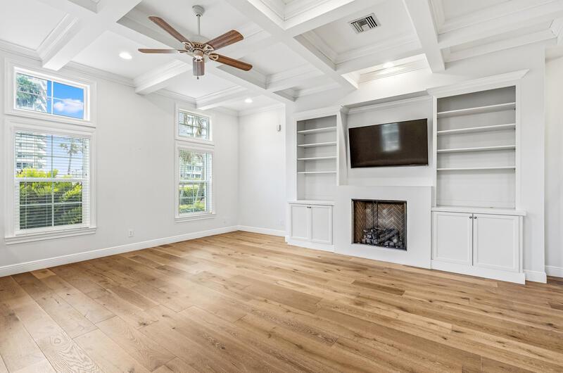 A living room features light wood floors, a coffered ceiling, built-in shelves, and a fireplace — VERO BEACH, FL