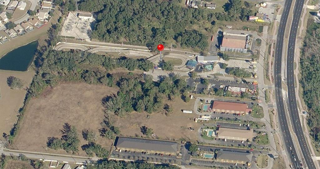 This aerial view shows a commercial property with a go-kart track and surrounding parking lots — 4708 W IRLO BRONSON MEMORIAL HIGHWAY, KISSIMMEE, FL