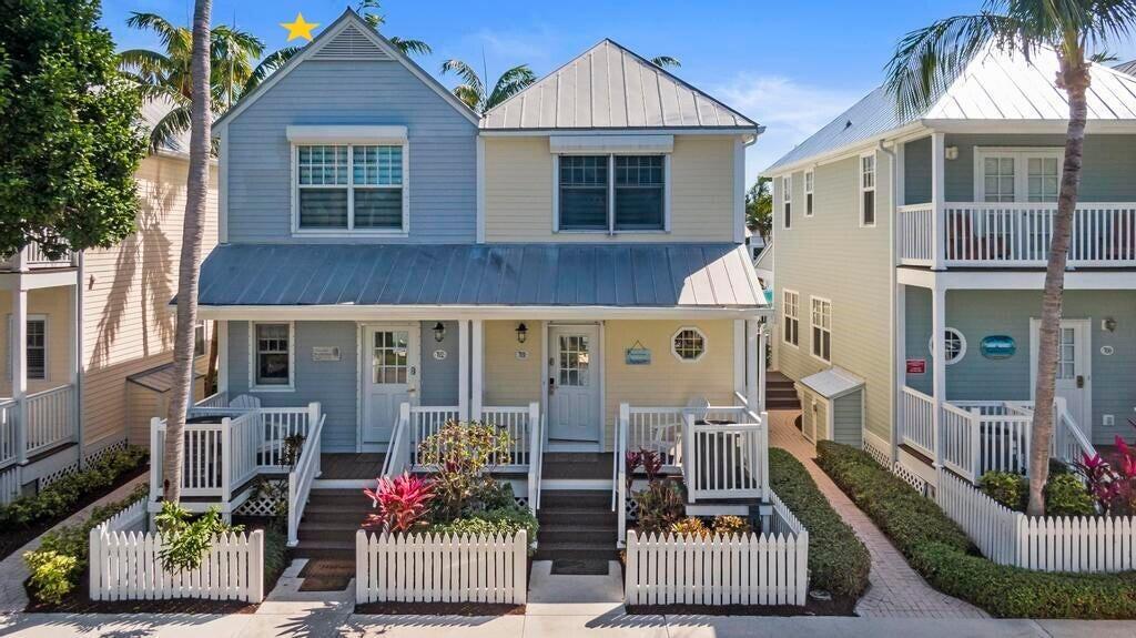 A two-story duplex house with light blue and yellow siding and a white picket fence — 7031 Harbor Village Drive # 7031, FL 33050, FL