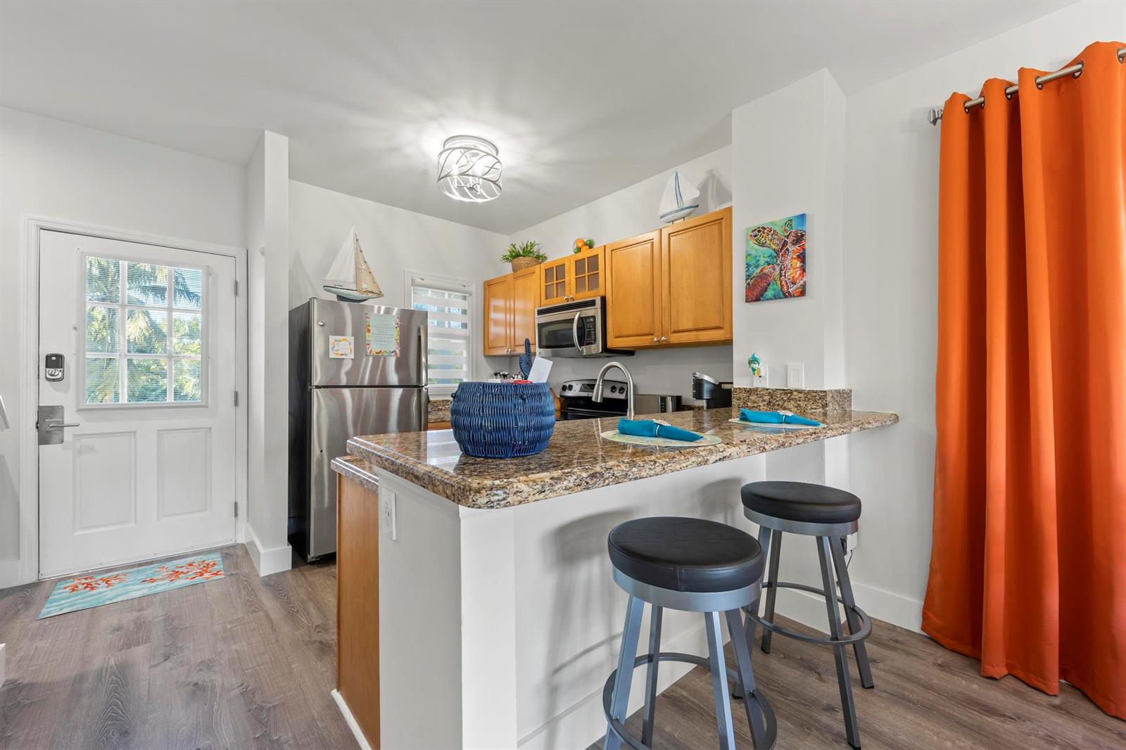 A kitchen with wood cabinets, granite countertops, a breakfast bar, and stainless steel appliances — 7031 Harbor Village Drive # 7031, FL 33050, FL