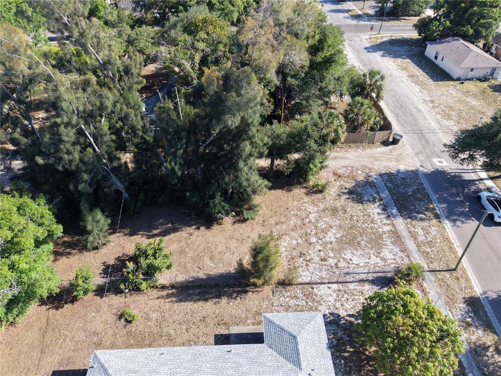 An aerial view shows a vacant, grassy lot adjacent to a house and a street — 14TH AVENUE S, ST PETERSBURG, FL