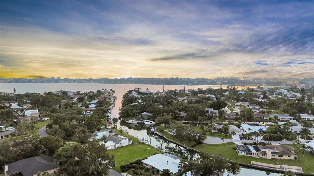 An aerial view shows a residential neighborhood with houses along a canal leading to a bay — 1849 BAYWOOD DRIVE, SARASOTA, FL