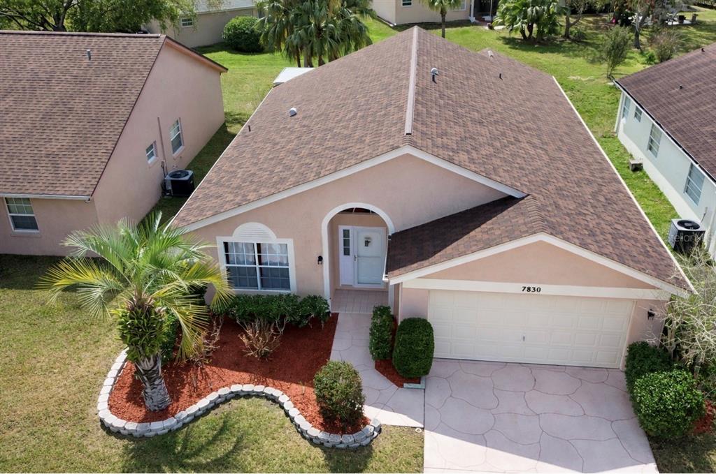 An aerial view shows a single-story house with a tan stucco exterior and brown roof — 7830 BECKET ST, NEW PORT RICHEY, FL