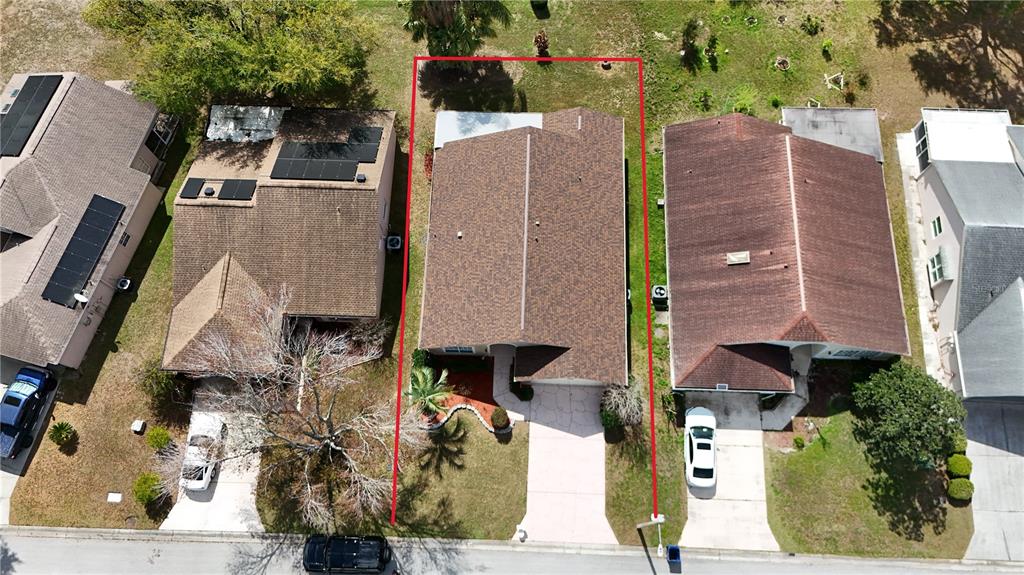An aerial view shows a single-story house with a brown roof and a concrete driveway — 7830 BECKET ST, NEW PORT RICHEY, FL