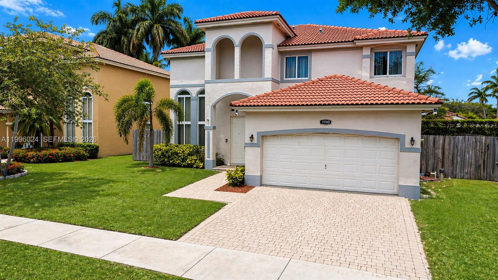 A living room features high ceilings, arched windows, tile flooring, and tufted gray furniture — 1910 SE 14th Cir, Homestead FL 33035, HOMESTEAD, FL