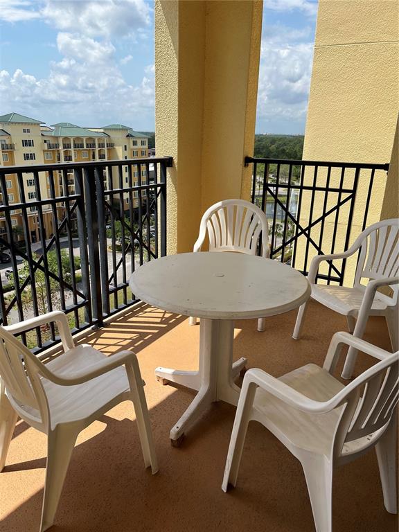 A balcony features a round white table and four matching plastic chairs — 8101 RESORT VILLAGE DRIVE UNIT 3909, ORLANDO, FL