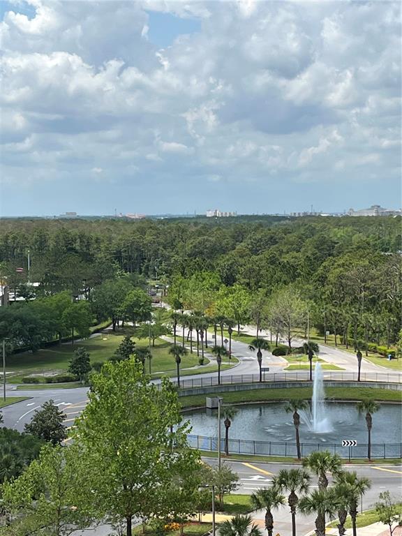 An elevated view shows a circular pond with a fountain surrounded by trees and roads — 8101 RESORT VILLAGE DRIVE UNIT 3909, ORLANDO, FL