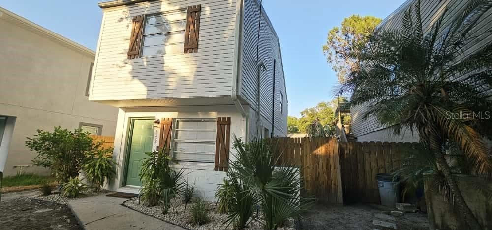 A two-story house with light-colored siding, brown shutters, and a green front door — 10213 N OJUS DRIVE, TAMPA, FL