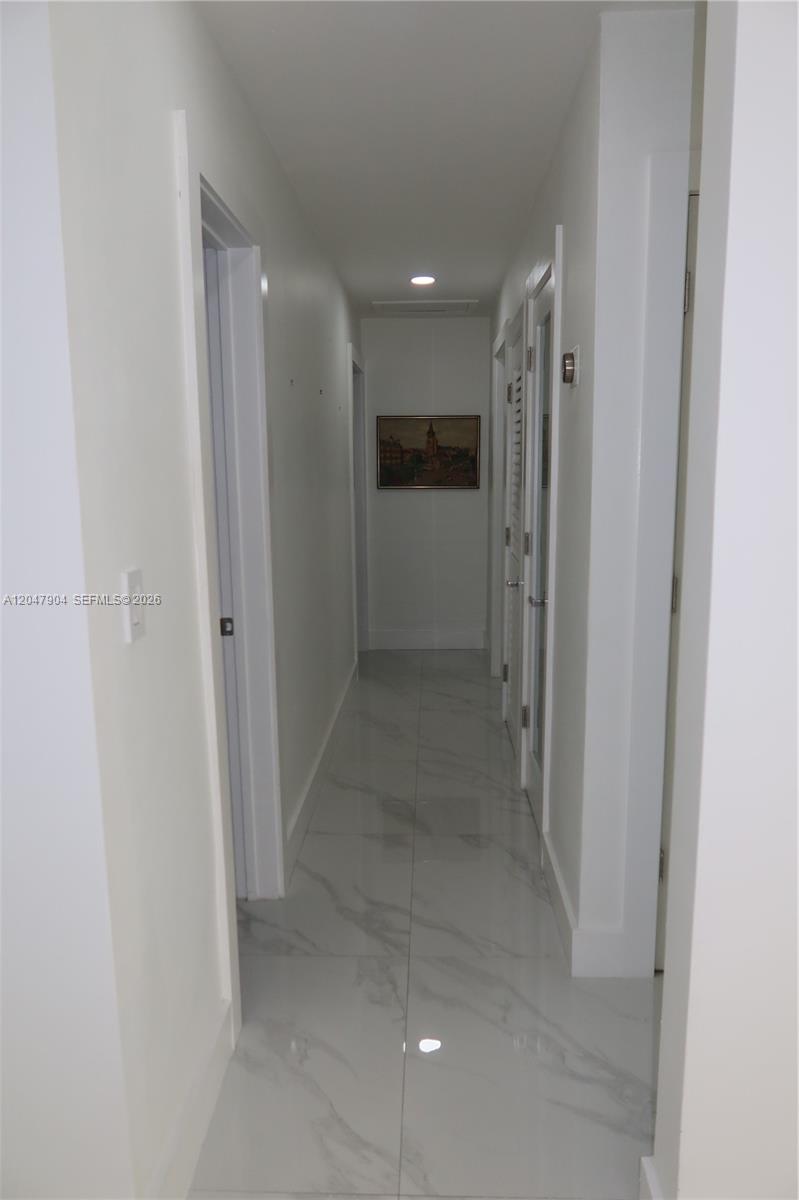 A narrow hallway features white walls, marble-patterned tile flooring, and several closed doors — 4401 SW 102nd Pl, Miami FL 33165, MIAMI, FL