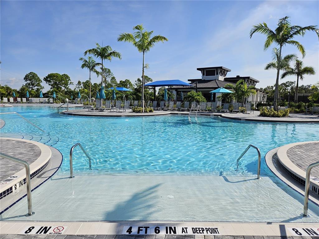 A resort-style swimming pool features a shallow entry area and a deep end — 17685 BORACAY COURT UNIT 101, VENICE, FL