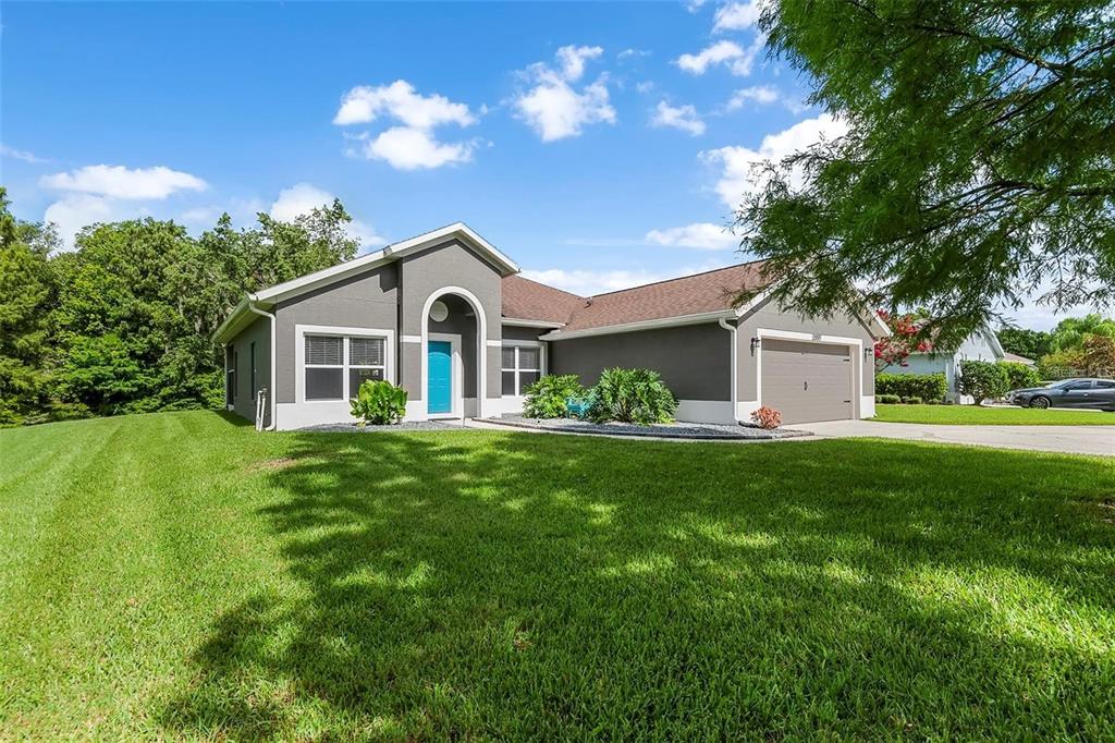 A single-story house with a gray exterior, a bright blue front door, and a two-car garage — 2997 CEDAR GLEN PLACE, OVIEDO, FL