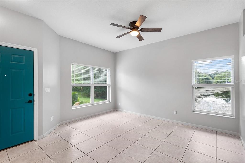 An empty room with light gray walls, tile flooring, a ceiling fan, and two windows — 2997 CEDAR GLEN PLACE, OVIEDO, FL