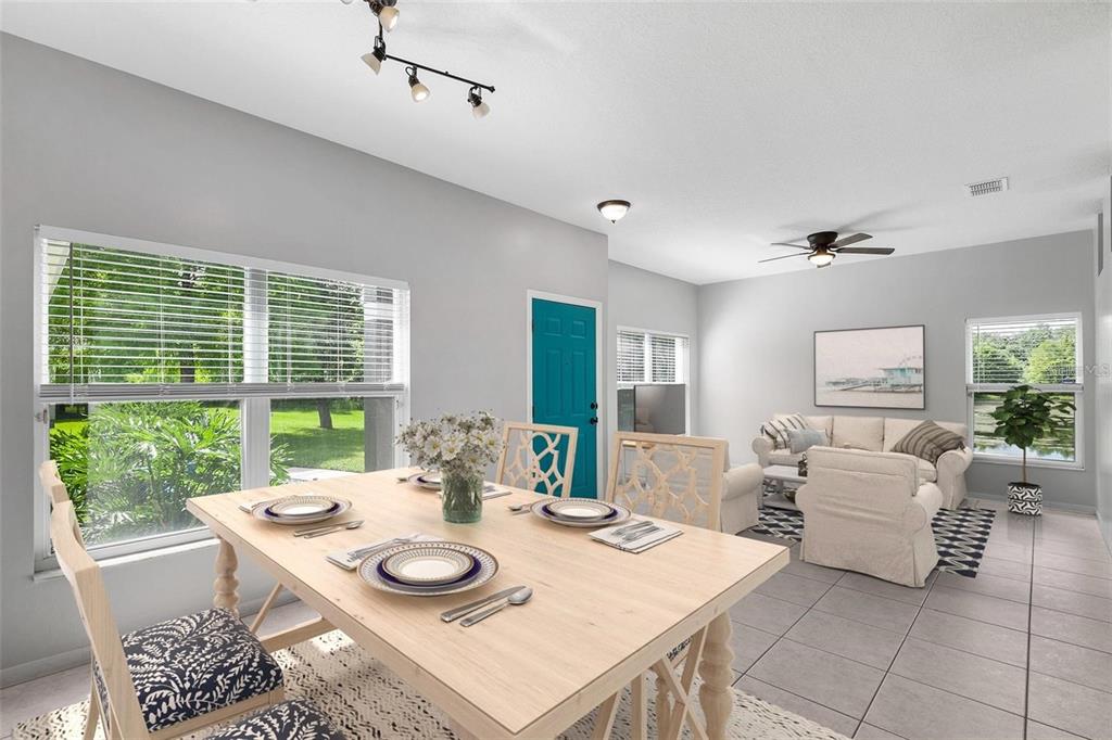 A dining area with a light wood table opens into a living room with tile floors — 2997 CEDAR GLEN PLACE, OVIEDO, FL