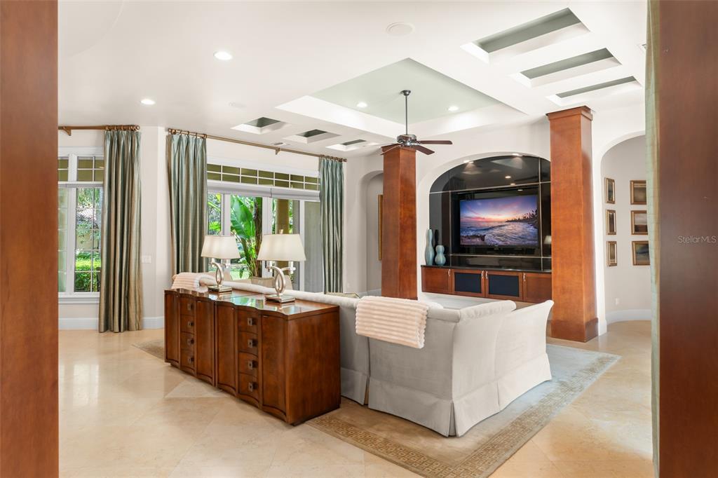 A living room features a large television, wooden columns, a ceiling fan, and a console table — 4819 ALEXANDRA GARDEN COURT, WINDERMERE, FL