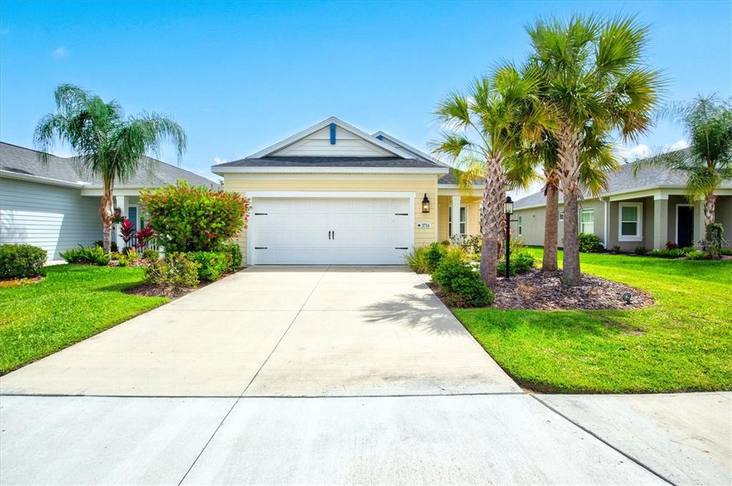 An aerial view shows a suburban house with a highlighted roofline overlooking a small pond — 3714 WOODMONT DRIVE, PARRISH, FL