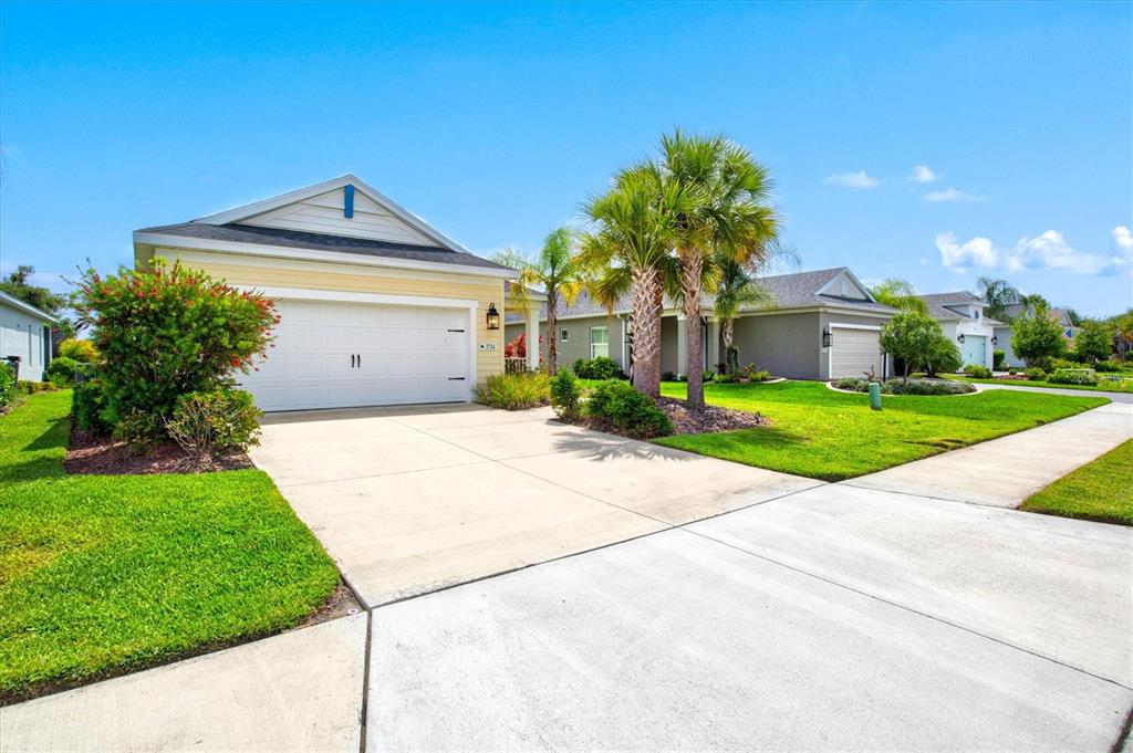 A covered concrete patio overlooks a pond with a chair and potted plants — 3714 WOODMONT DRIVE, PARRISH, FL