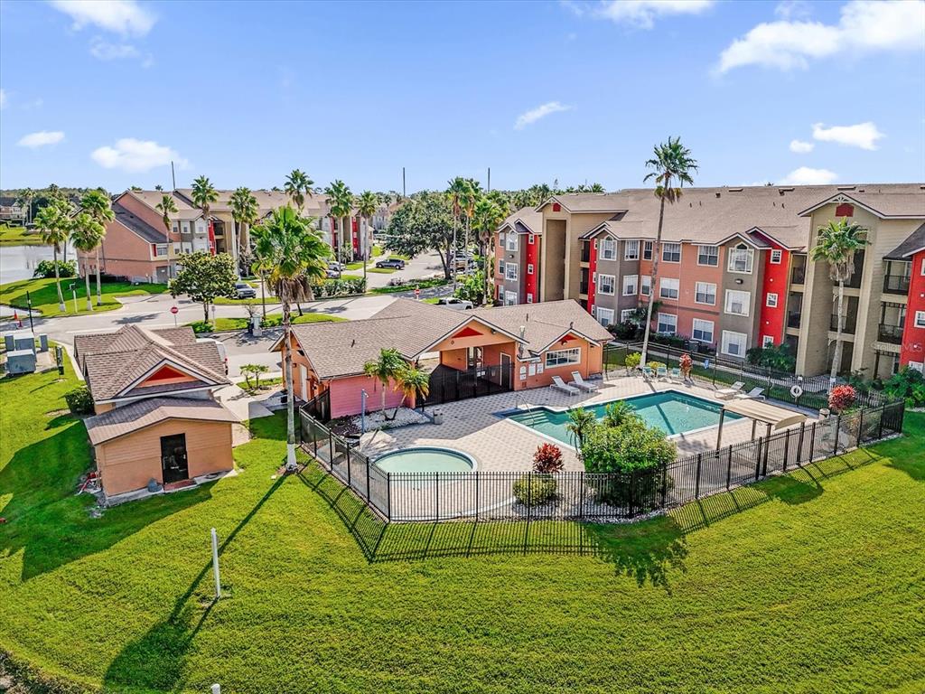 An aerial view shows an apartment complex with a swimming pool and a clubhouse — 2218 GRAND CAYMAN COURT, KISSIMMEE, FL