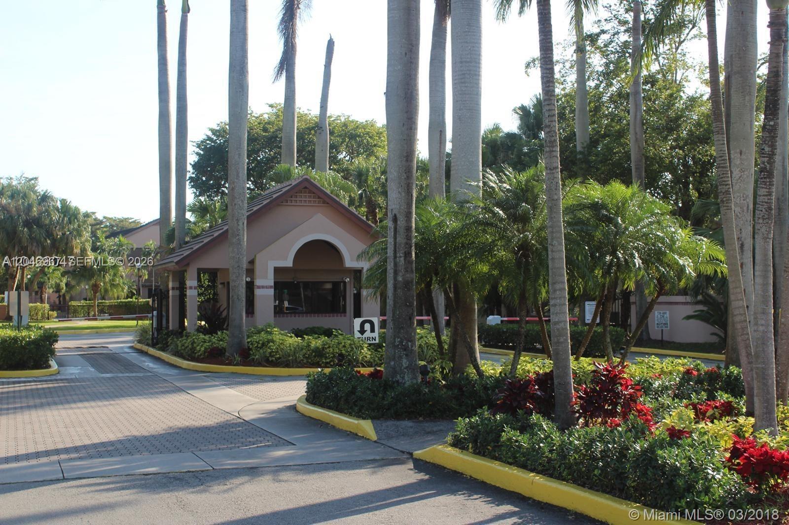 A gated community entrance features a guardhouse, palm trees, and a U-turn sign — 9257 SW 138th Pl # 9257, Miami FL 33186, MIAMI, FL