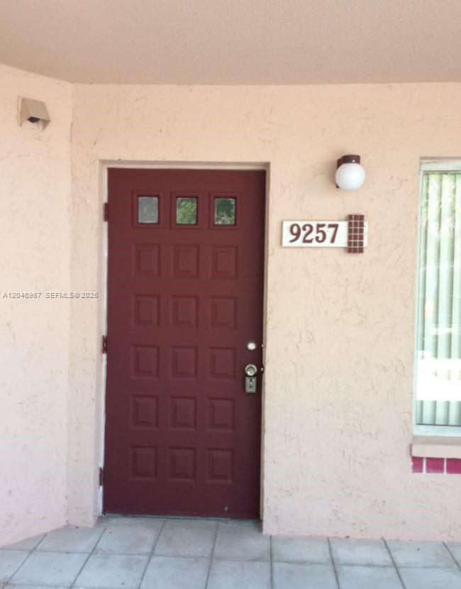 A maroon front door with three small windows sits next to a house number sign — 9257 SW 138th Pl # 9257, Miami FL 33186, MIAMI, FL