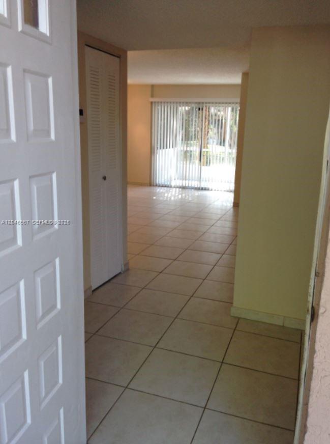 An interior view shows a tiled entryway leading to a living area with sliding doors — 9257 SW 138th Pl # 9257, Miami FL 33186, MIAMI, FL