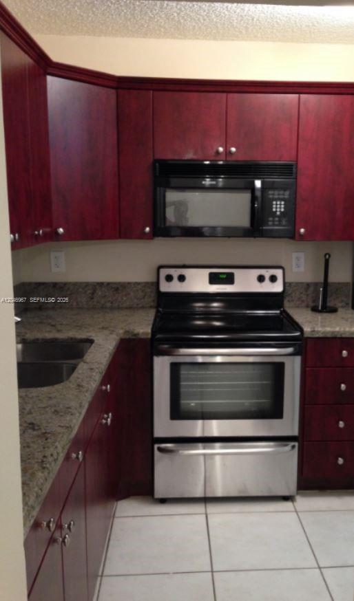 A kitchen features dark wood cabinets, granite countertops, and stainless steel appliances — 9257 SW 138th Pl # 9257, Miami FL 33186, MIAMI, FL