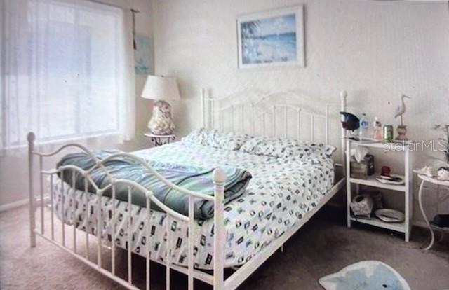 A bedroom features a white metal bed frame, a patterned comforter, and a white shelving unit — 3224 MOUNT HOPE STREET, NORTH PORT, FL