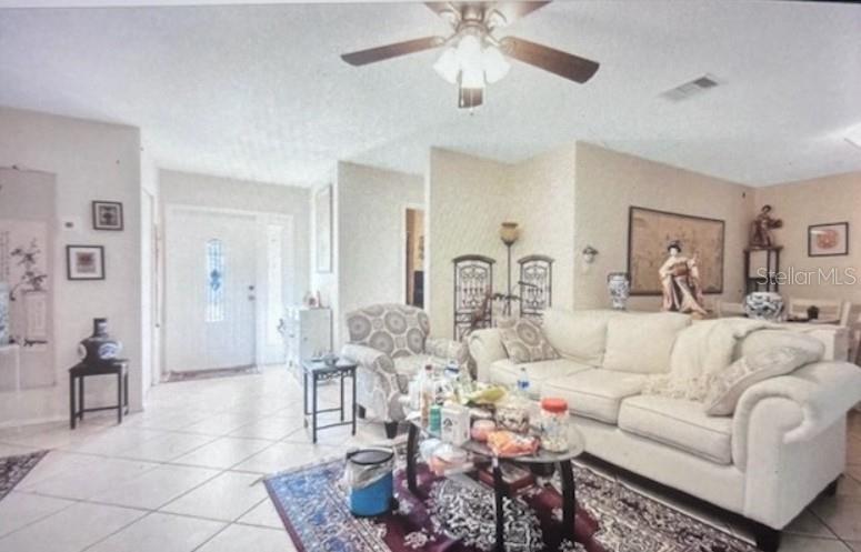 A living room features tile flooring, a ceiling fan, and a white sofa — 3224 MOUNT HOPE STREET, NORTH PORT, FL
