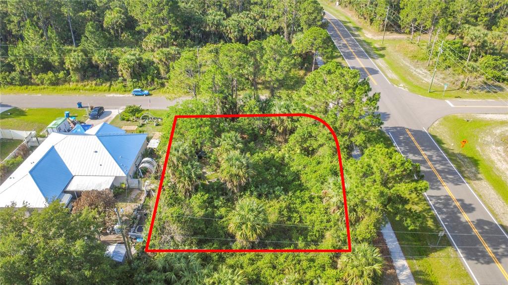 An aerial view shows a wooded, rectangular vacant lot bordered by a road and house — 0 DEGROODT ROAD SW, PALM BAY, FL