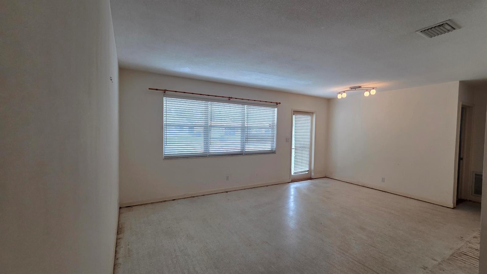 An empty room with white walls, a large window with blinds, and a glass door — 2000 N 31st Avenue, Hollywood FL 33021, HOLLYWOOD, FL