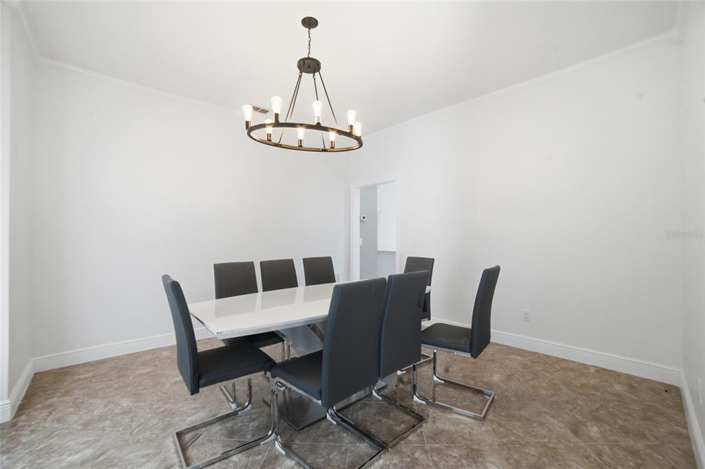 A dining room features a white table, six gray chairs, and a circular chandelier — 2054 PALM VISTA DRIVE, APOPKA, FL
