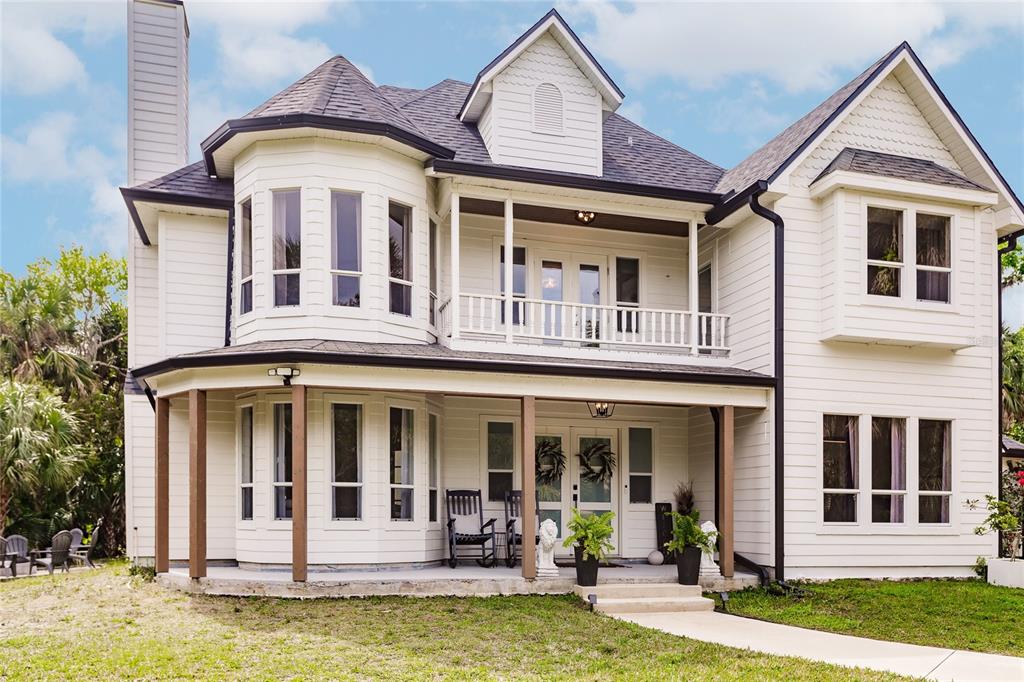 A two-story white house with a wrap-around porch, a balcony, and a bay window — 1587 FIRETHORNE LAKES DRIVE, SARASOTA, FL