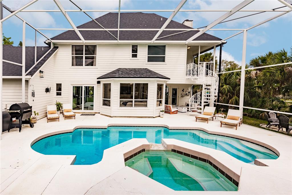 A two-story house with a screened-in pool, hot tub, and white exterior siding — 1587 FIRETHORNE LAKES DRIVE, SARASOTA, FL