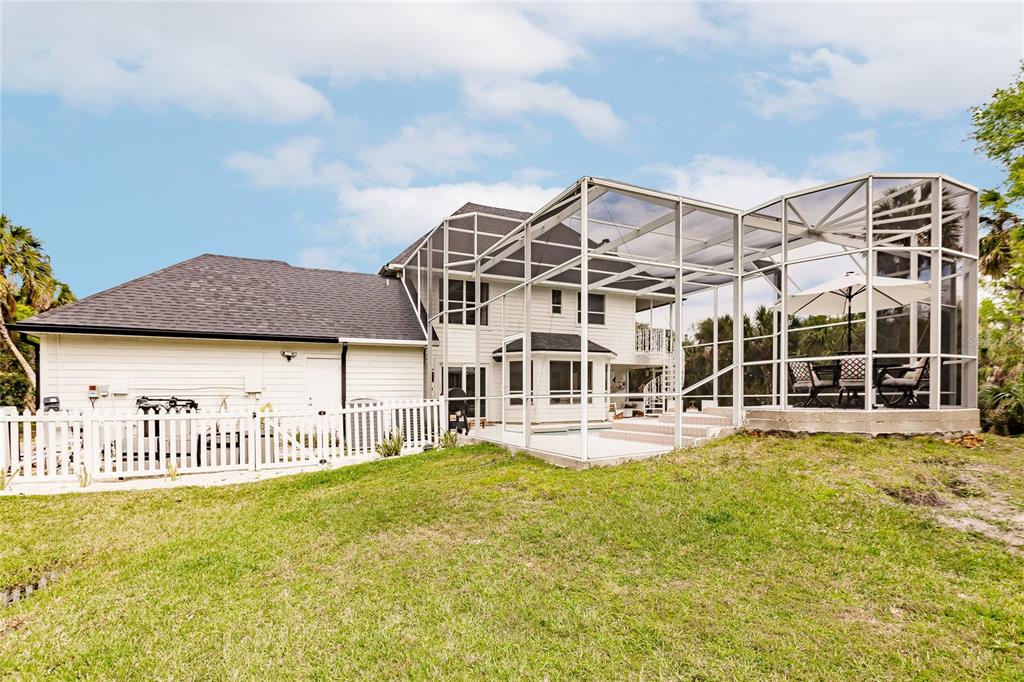 A two-story house with white siding, a dark shingled roof, and a screened-in pool enclosure — 1587 FIRETHORNE LAKES DRIVE, SARASOTA, FL