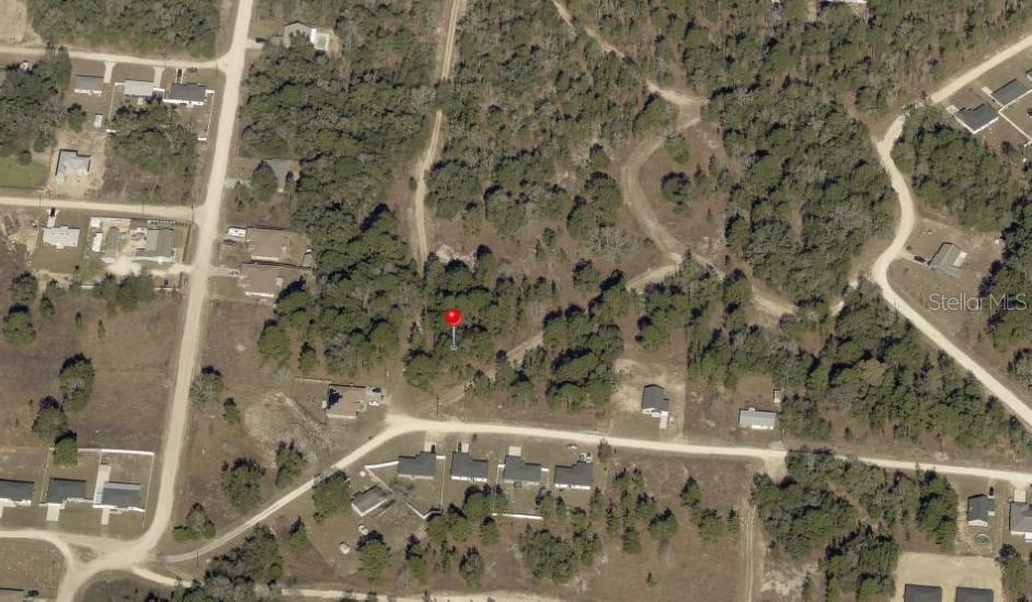 This aerial map shows a wooded residential lot marked with a red pin — SW 145TH CT, DUNNELLON, FL