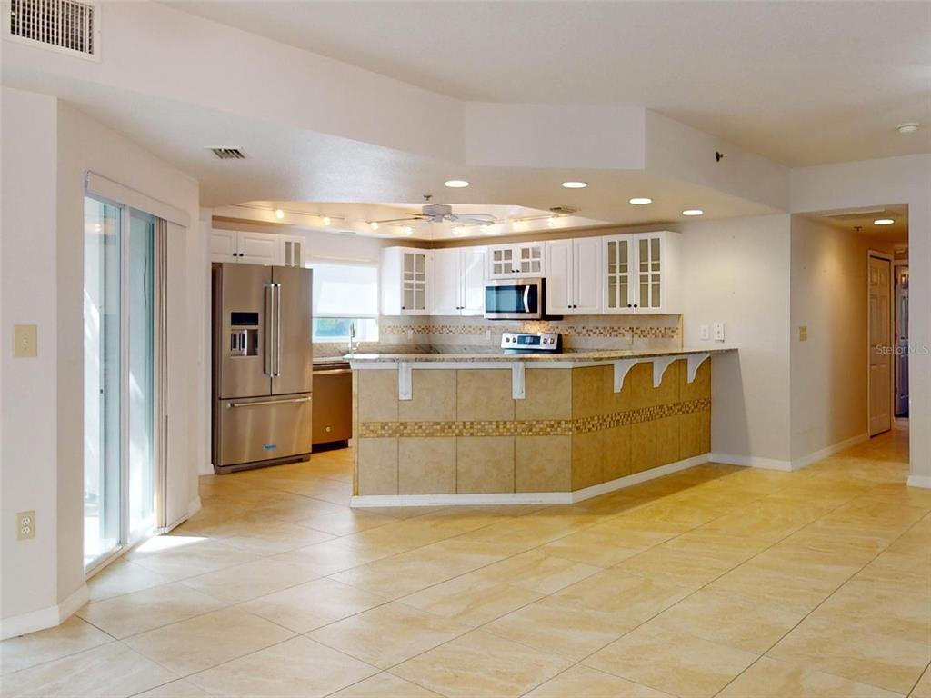 A kitchen with white cabinets, stainless steel appliances, and a tiled breakfast bar — 5300 S ATLANTIC AVENUE UNIT 9201, NEW SMYRNA BEACH, FL