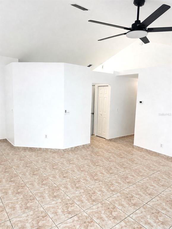 An interior view of a room with white walls, tiled flooring, and a ceiling fan — 1901 ASHLEY OAKS COURT, ST CLOUD, FL