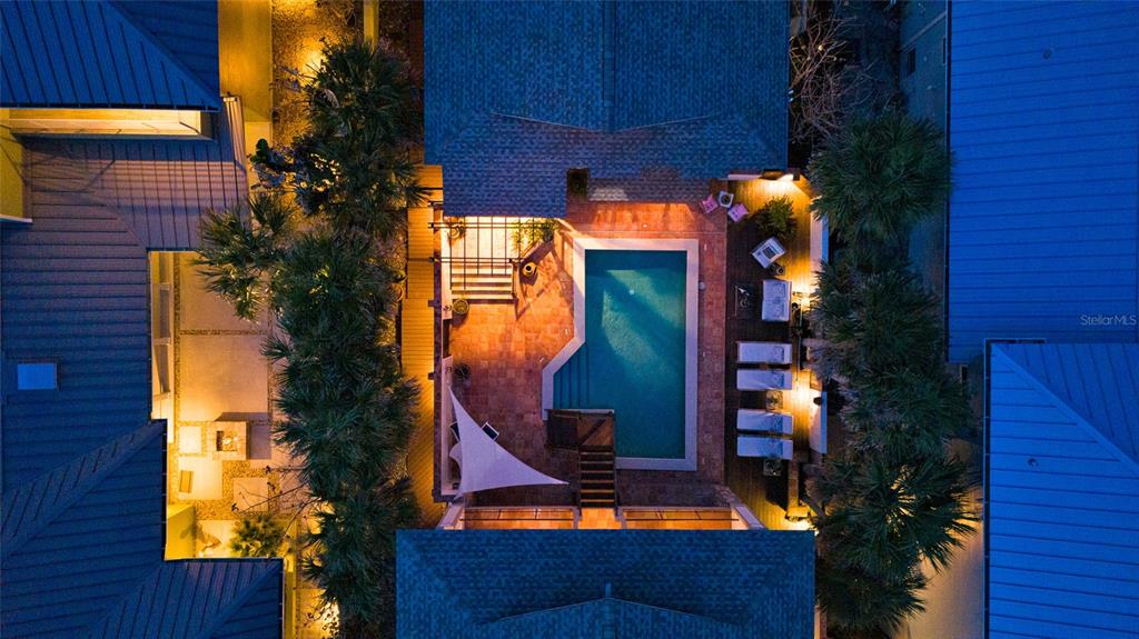 An aerial view shows a swimming pool and patio area nestled between residential buildings — 1421 N ATLANTIC AVENUE, NEW SMYRNA BEACH, FL