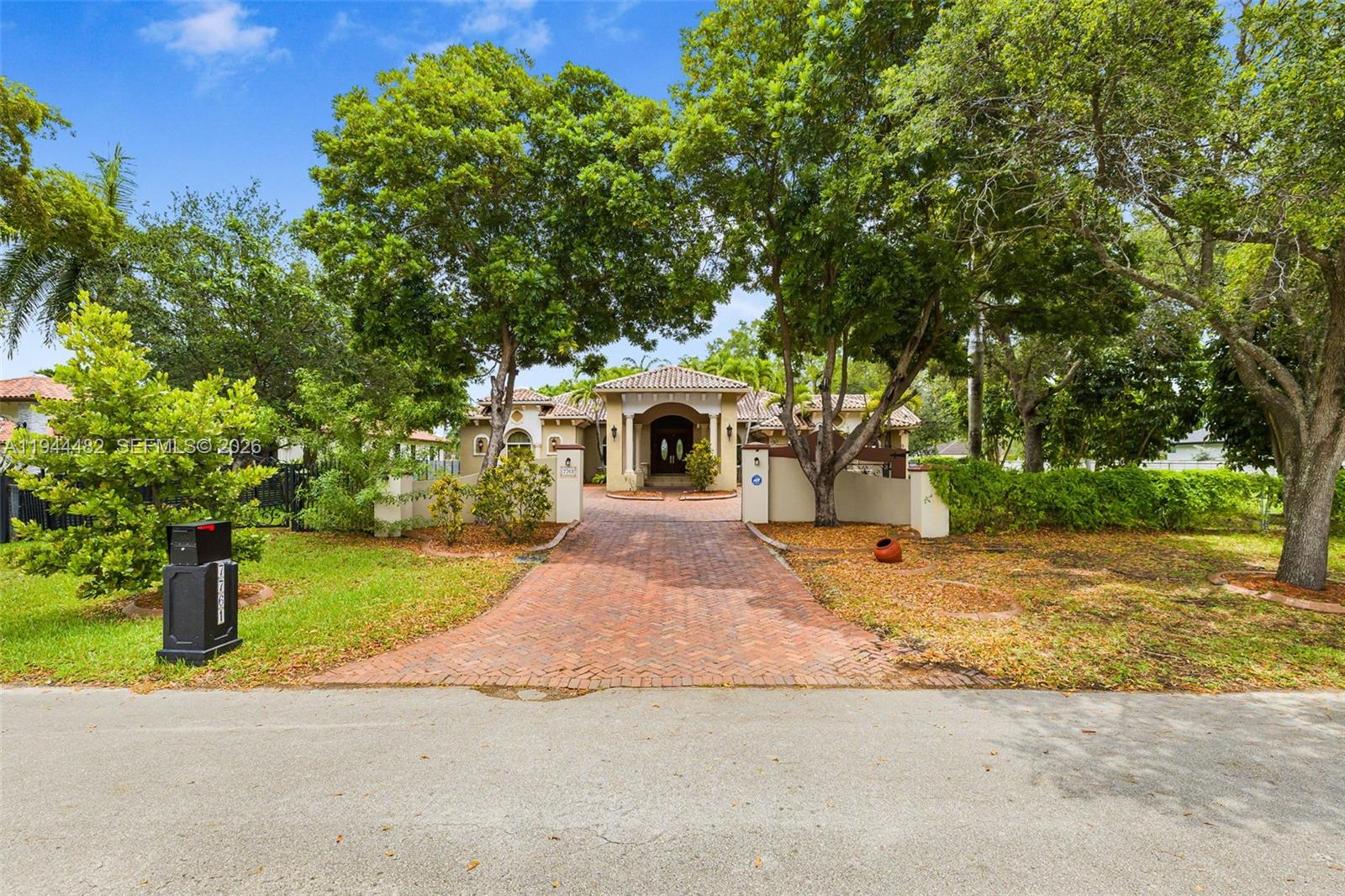 A brick driveway leads to the entrance of a single-story house with mature trees — 7761 SW 122nd Ave, Miami FL 33183, MIAMI, FL