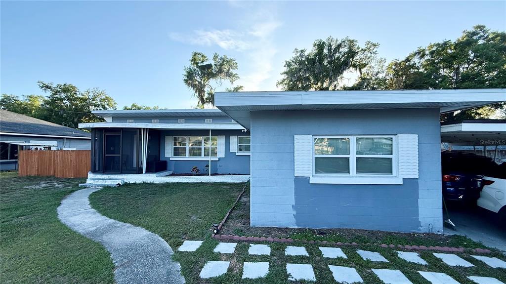 A blue single-story house with a screened porch, a concrete walkway, and a carport — 811 22ND STREET NW, WINTER HAVEN, FL
